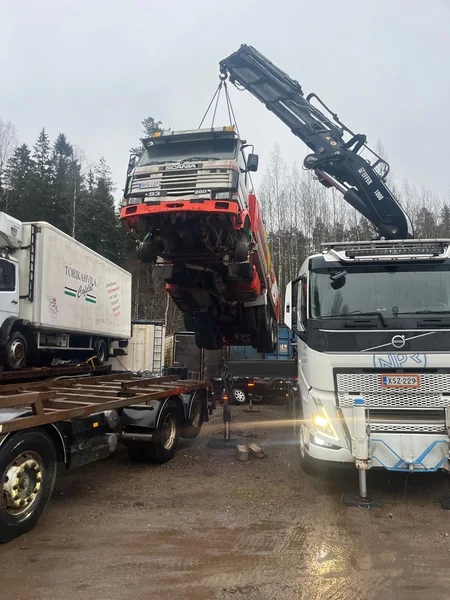 Kuorma-auto nosturin varassa kuljetuslavetin yläpuolella.