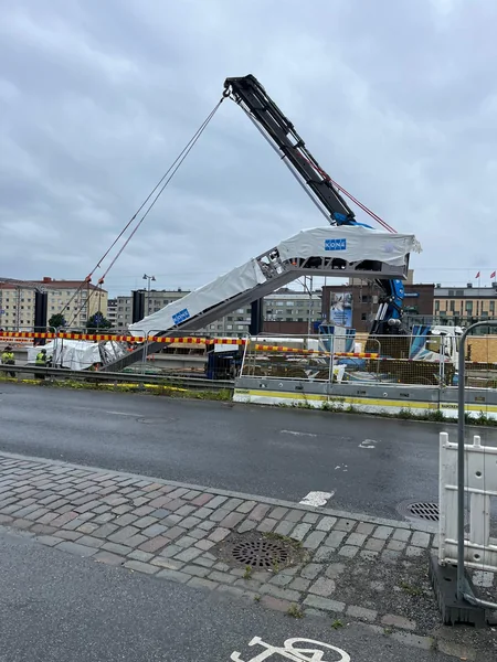 Liukuporras nosturilla nostettavana rakennuksen edustalla.